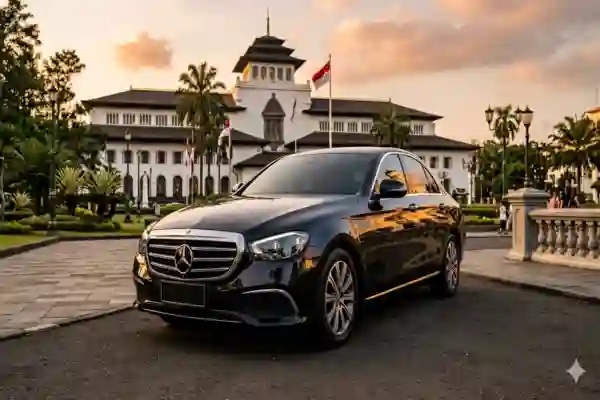 Sewa mobil pengantin Mercedes-Benz E-Class hitam di Bandung dengan latar ikonik Gedung Sate.